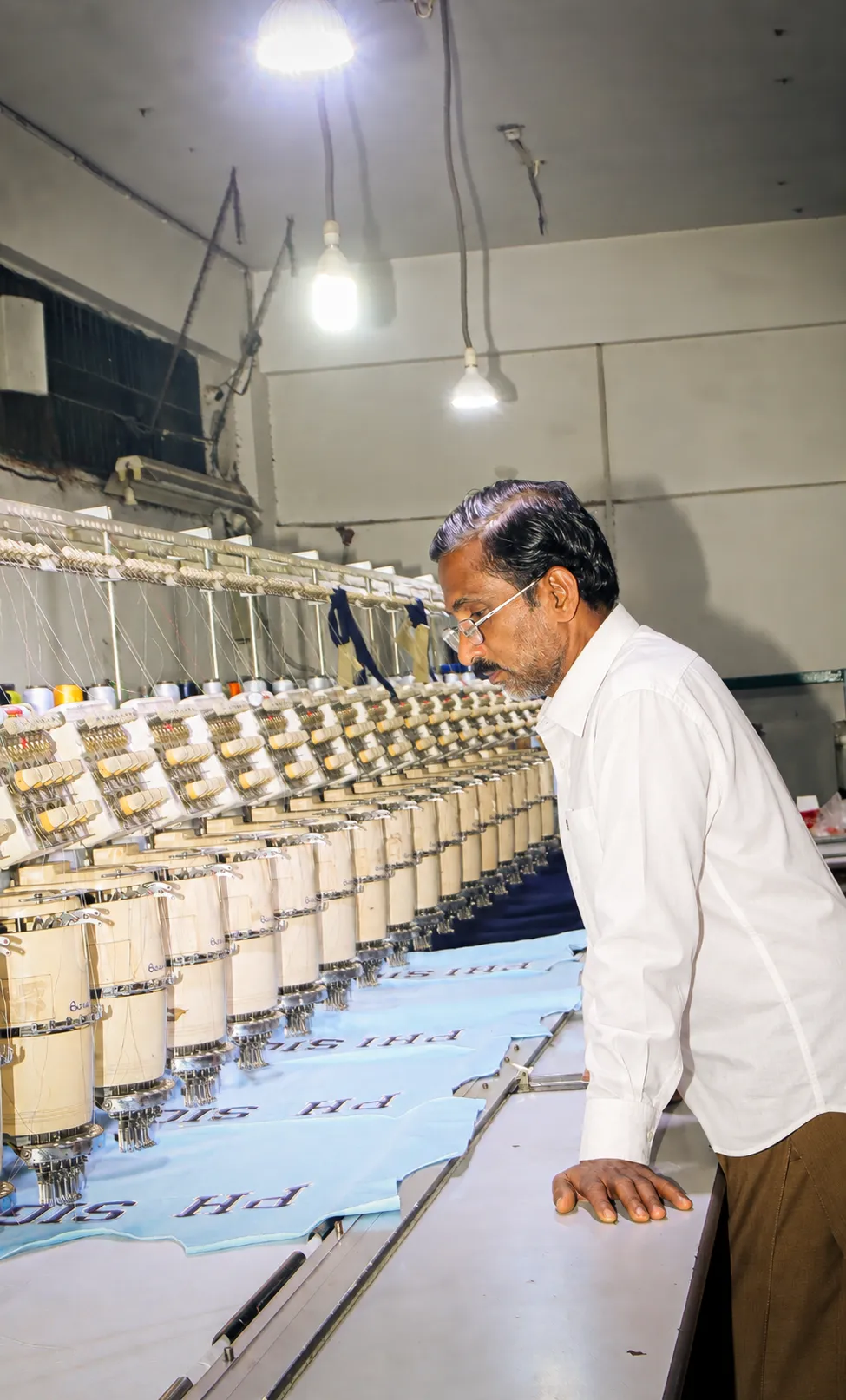 A ScreenCraft team member working at an embroidery machine